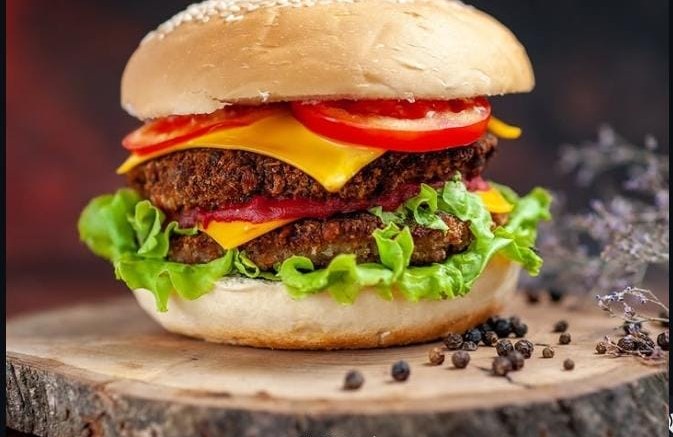 Triple cheese gourmet burger on a wooden board